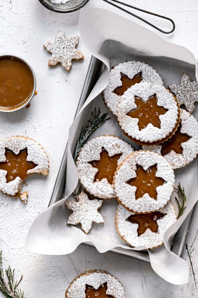 christmas linzer cookies in parchment lined baking sheet