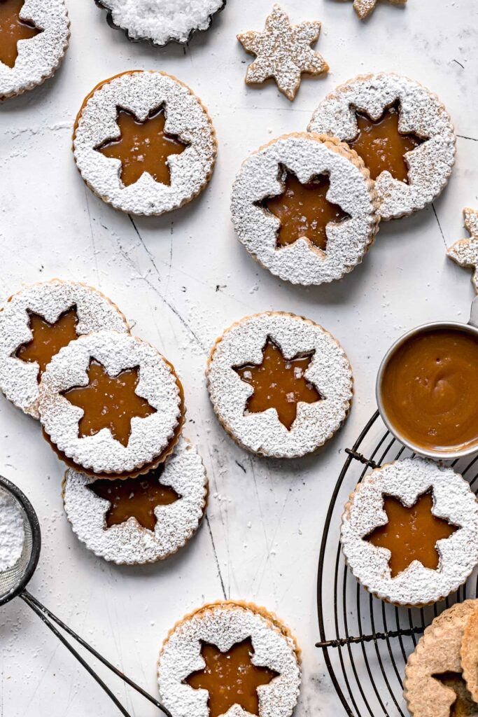 shortbread linzer cookies with salted caramel sauce on white background