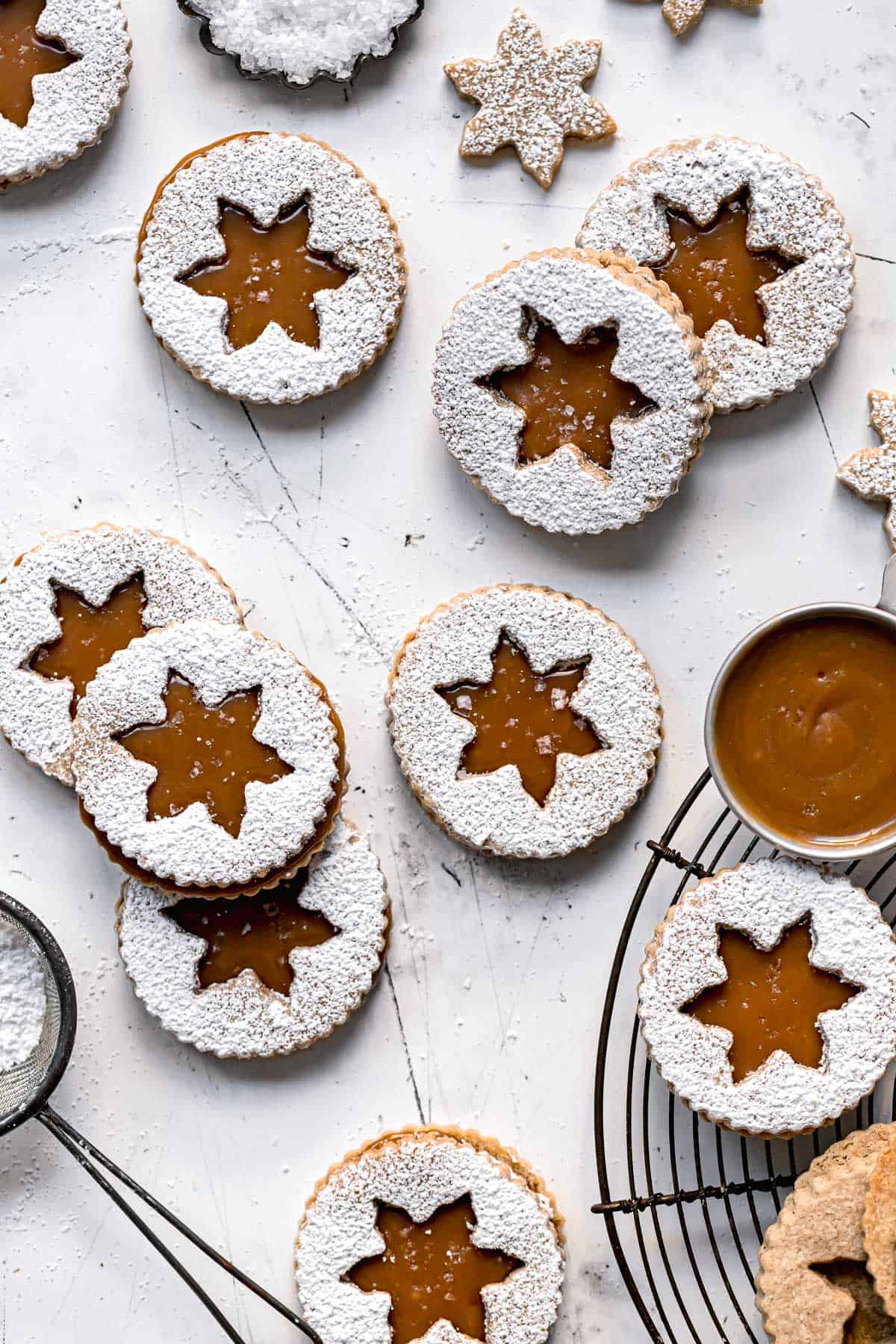 shortbread linzer cookies with salted caramel sauce on white background.
