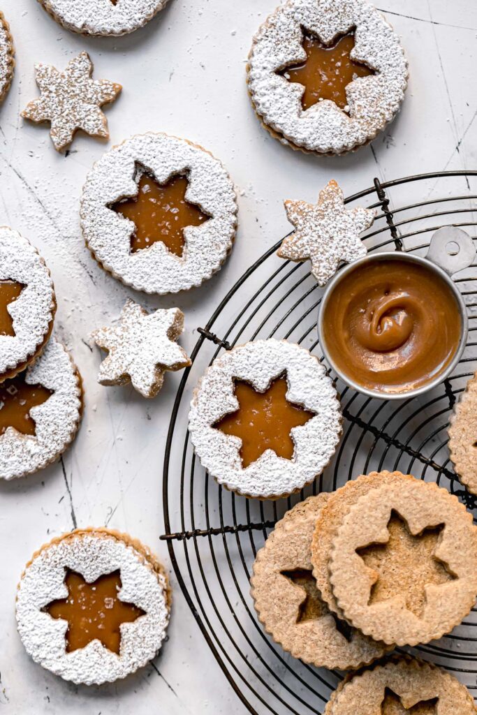 almond flour linzer cookies with caramel sauce and dusted with powdered sugar