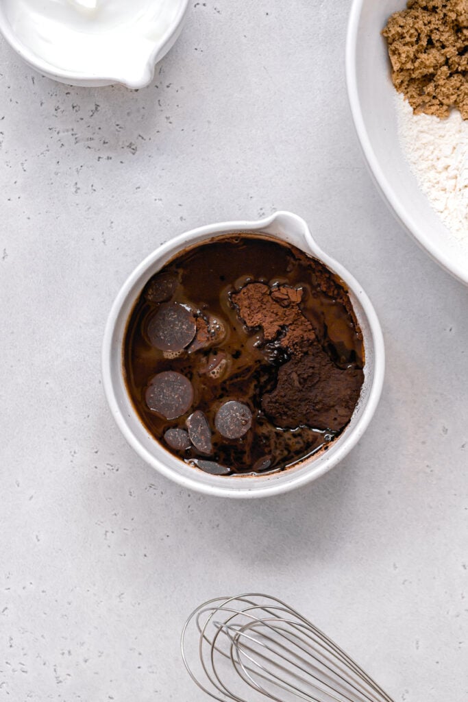 cocoa powde, chocolate, and hot coffee in white bowl