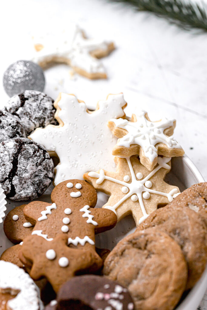 snowflake sugar cookies with other festive cookies in white bowl
