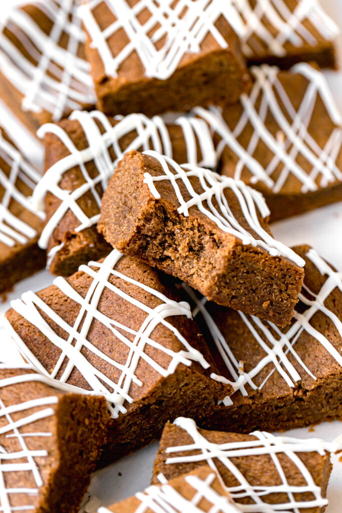 gingerbread blondies in a pile with bite taken out of one