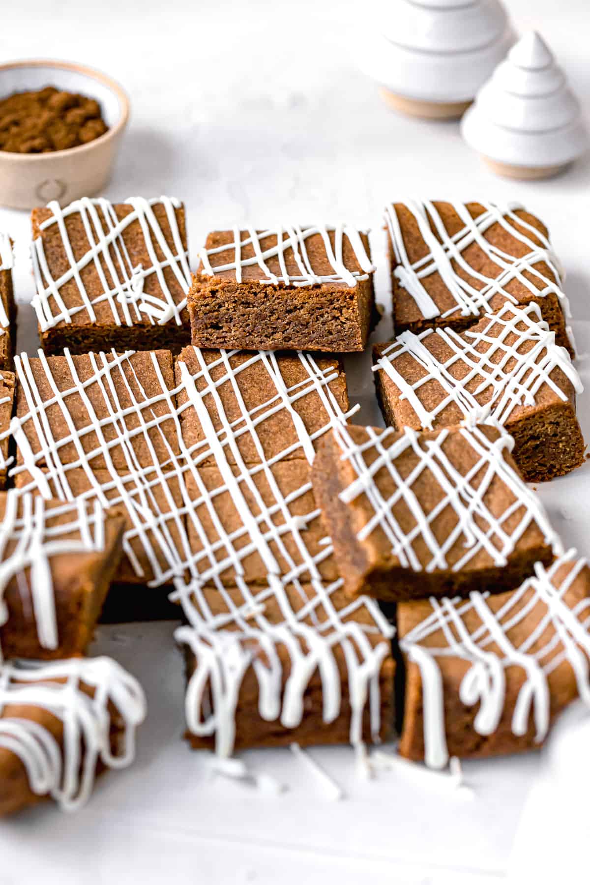 white chocolate gingerbread blondies cut into squares on parchment paper.