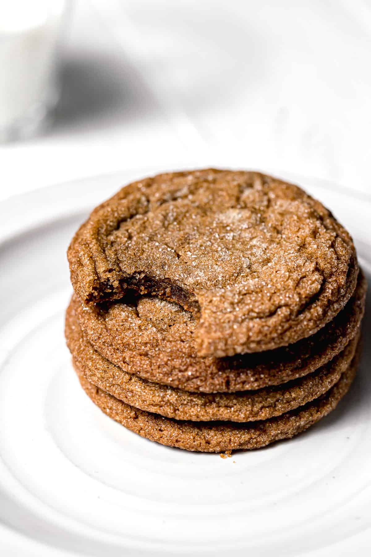 molasses cookies stacked on white plate.