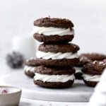 peppermint mocha cookies sandwiched with whipped white chocolate ganache stacked on marble plate