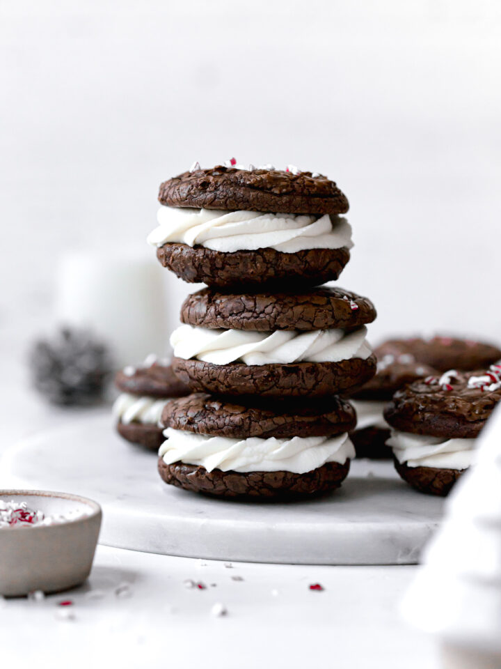 peppermint mocha cookies sandwiched with whipped white chocolate ganache stacked on marble plate