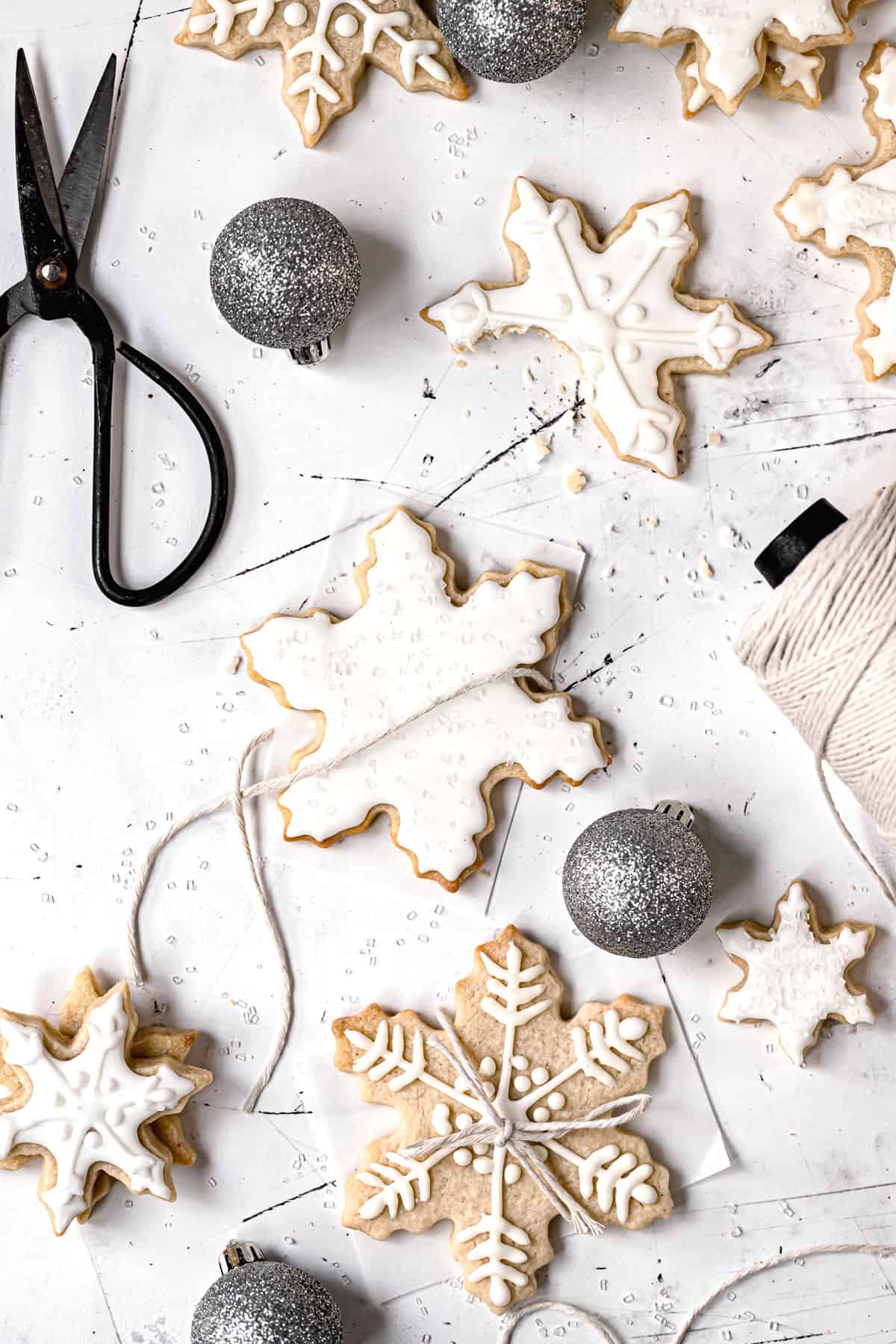 snowflake sugar cookies being wrapped in kitchen twine.
