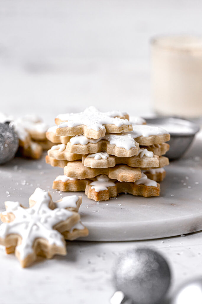 snowflake sugar cookies stacked on marble slab
