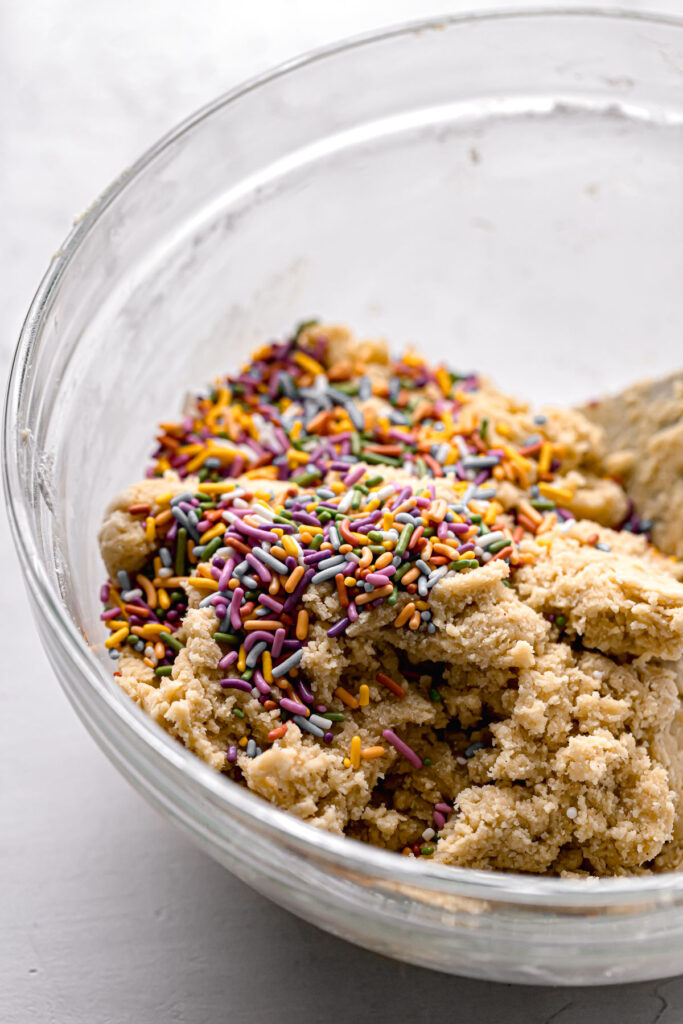 birthday cake cookie dough with rainbow sprinkles in glass bowl