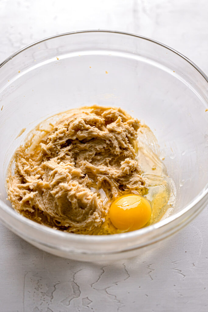 egg added to butter, sugar mixture in glass bowl