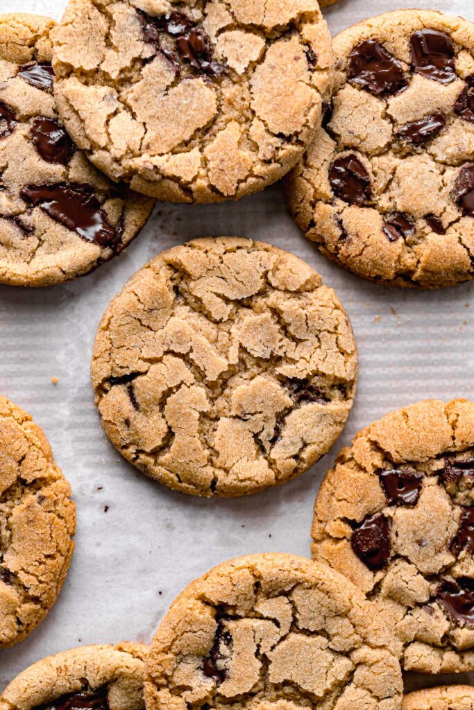 pan-banging chocolate chip cookies on baking sheet