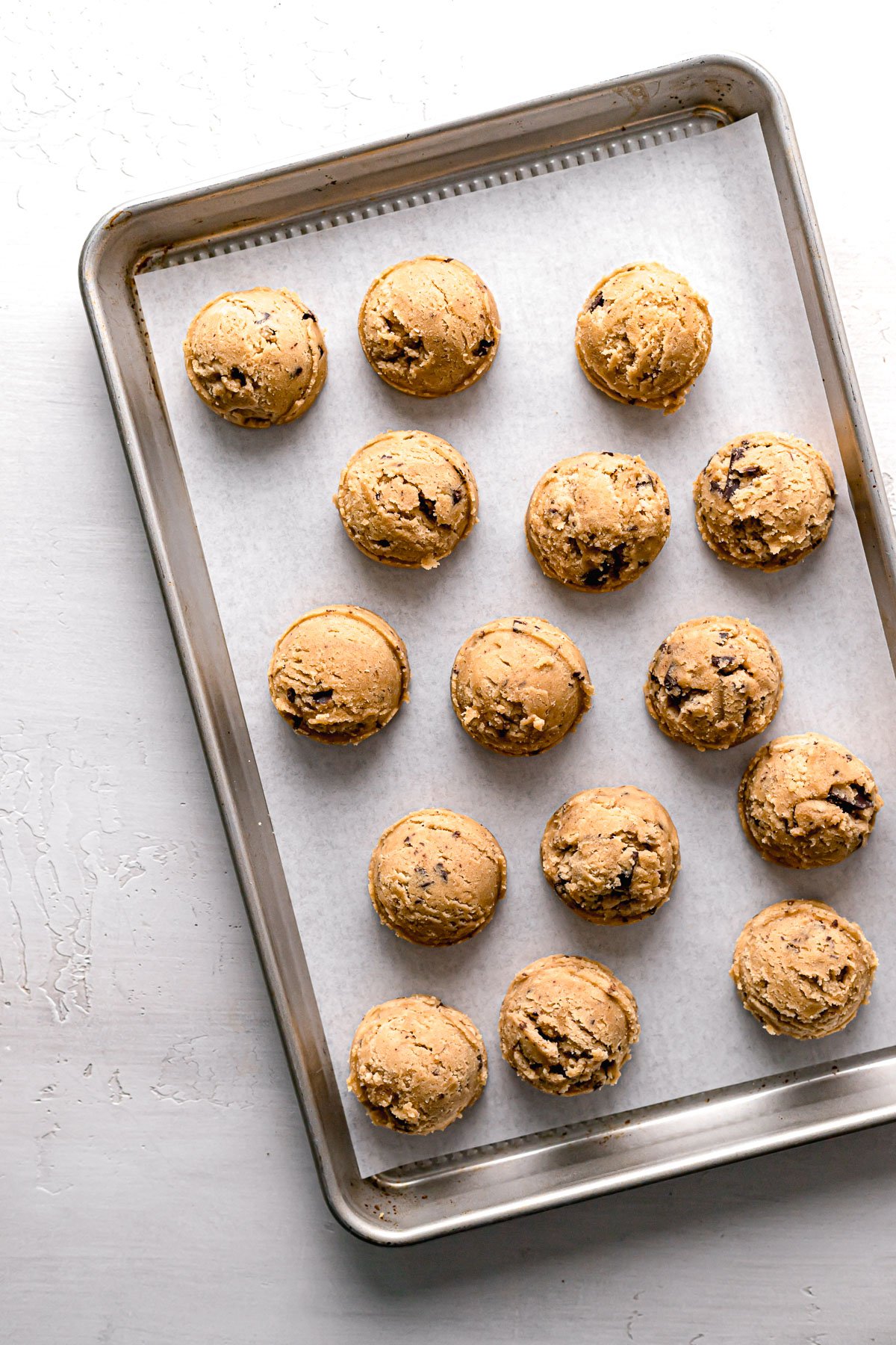 chocolate chip peanut butter cookie dough balls on baking sheet.