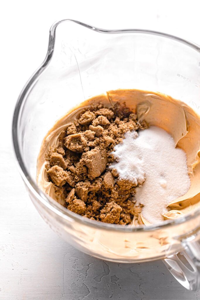 sugar added to creamed peanut butter and butter in glass bowl