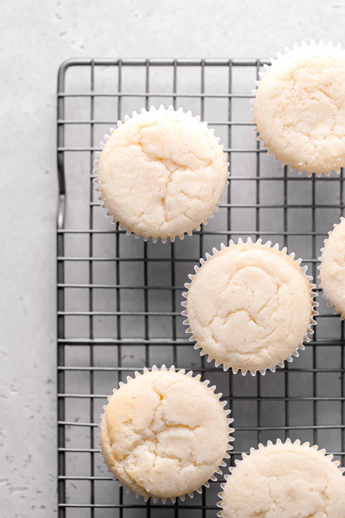 freshly baked vanilla cupcakes on wire rack.