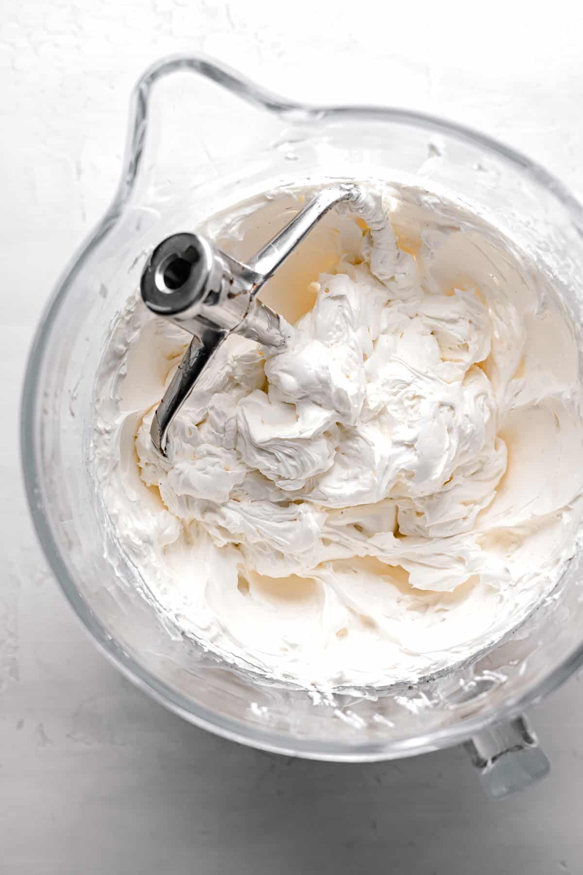 smooth swiss meringue buttercream with paddle attachment in glass bowl.