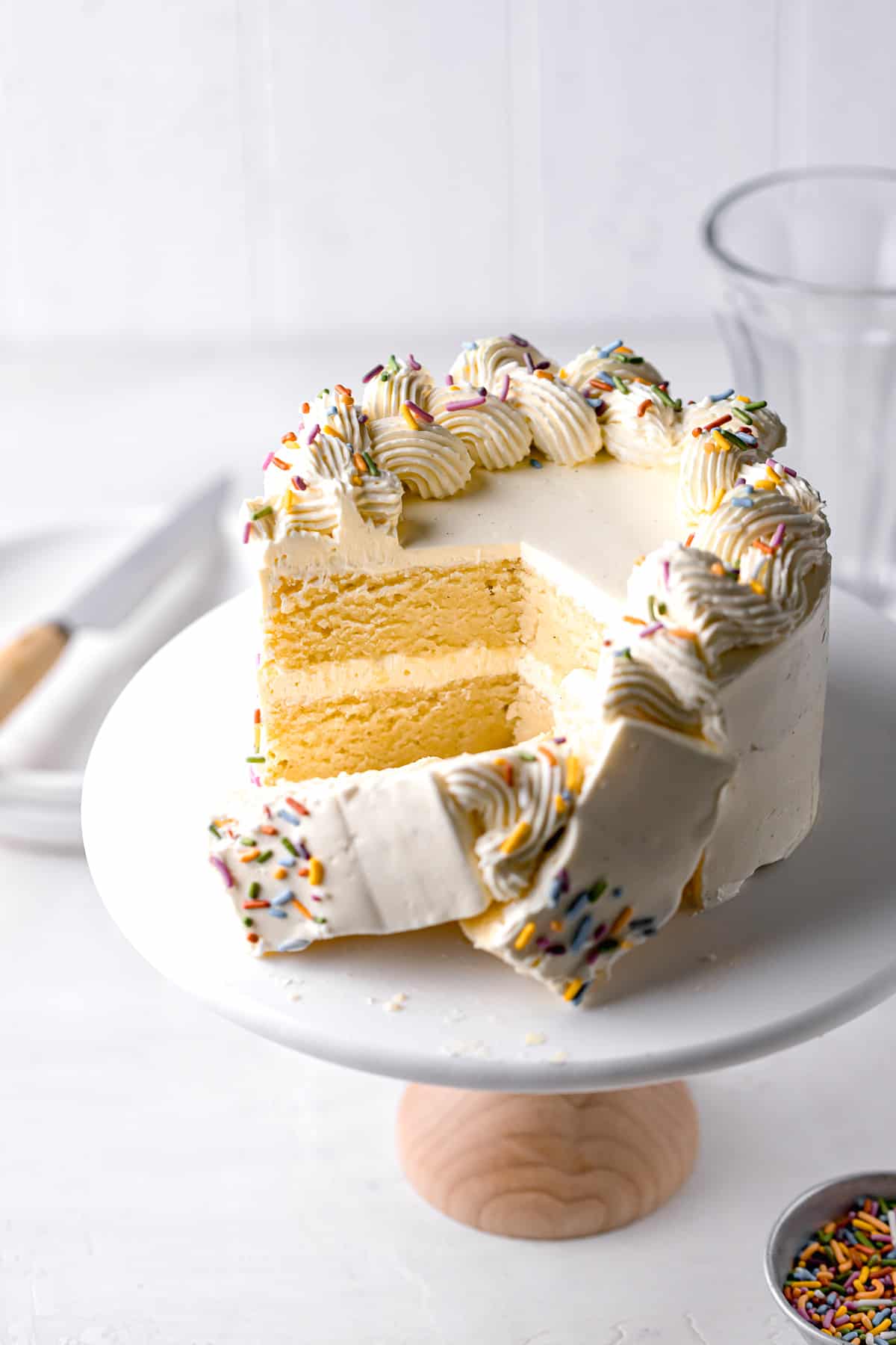 small vanilla cake recipe with swiss meringue buttercream cut to reveal interior.
