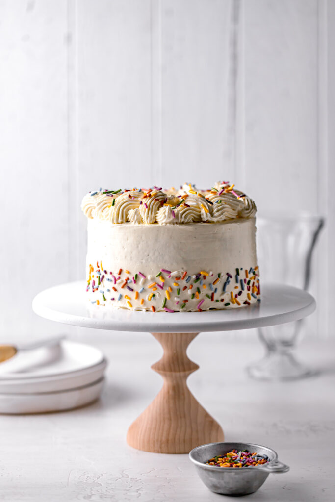 small birthday cake with swiss meringue buttercream on cake stand