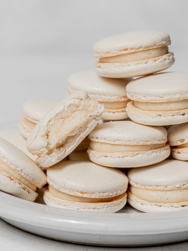 vanilla macarons stacked on plate.