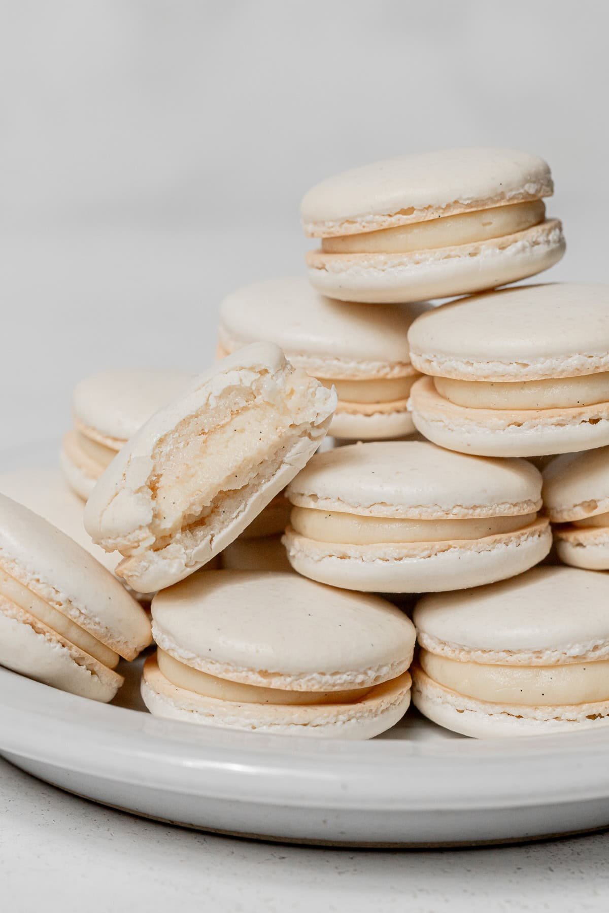 vanilla macarons stacked on plate.