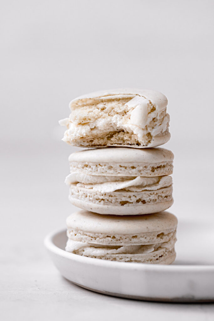 vanilla macarons stacked on white plate