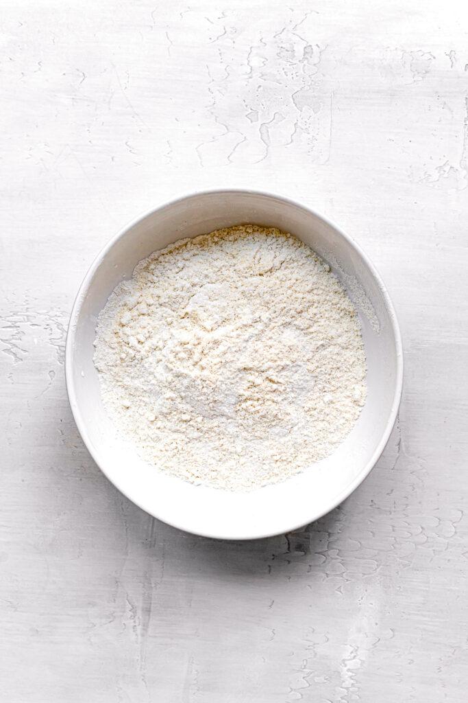 powdered sugar and almond flour sifted into white bowl