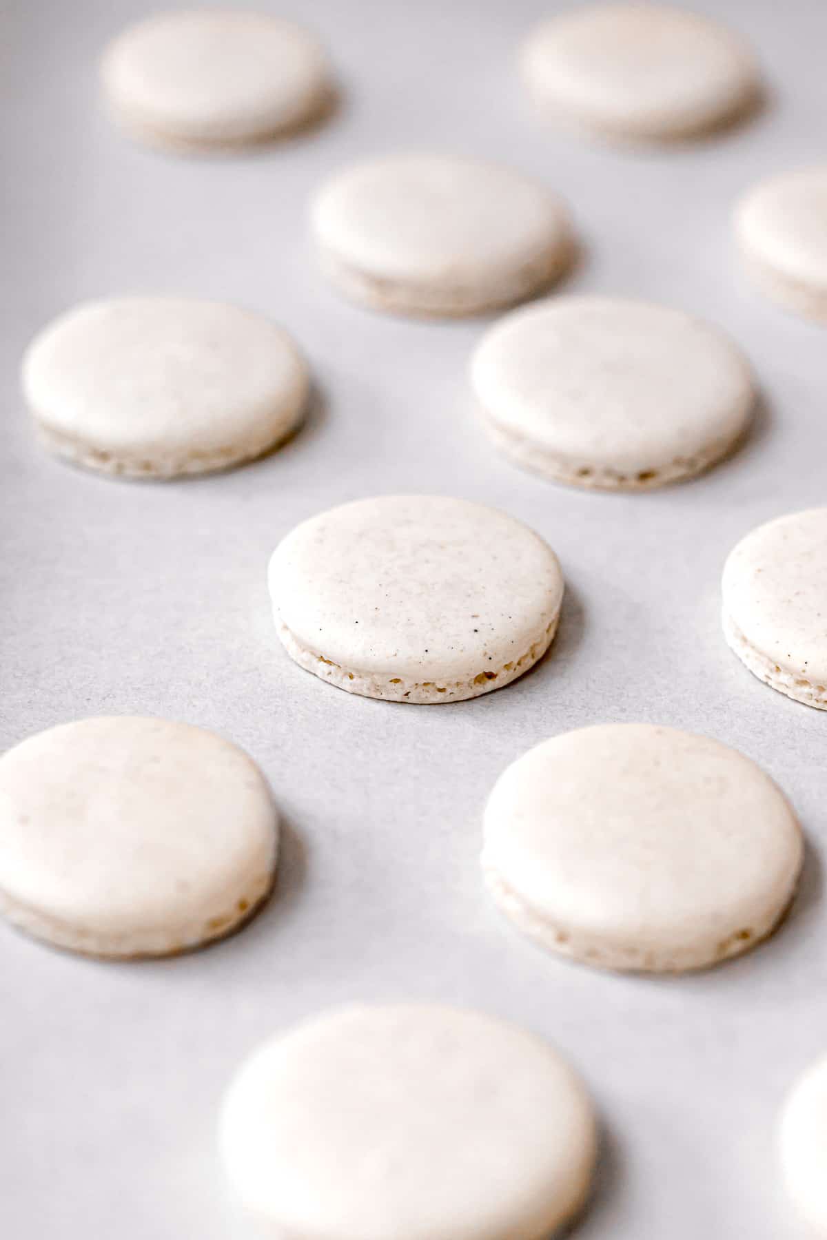baked macarons on parchment lined baking sheet.