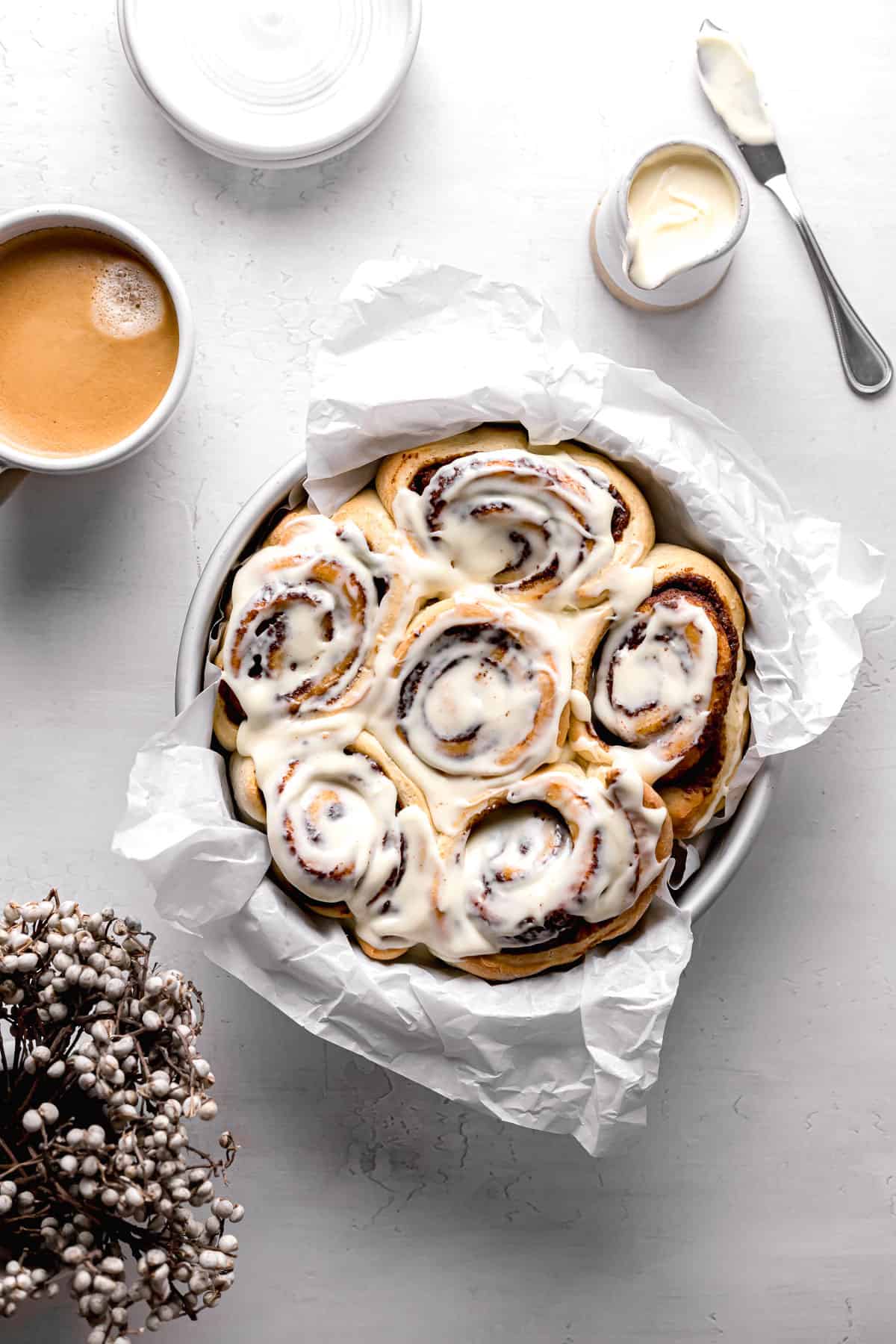 brown butter cardamom cinnamon rolls with cream cheese icing in cake pan.
