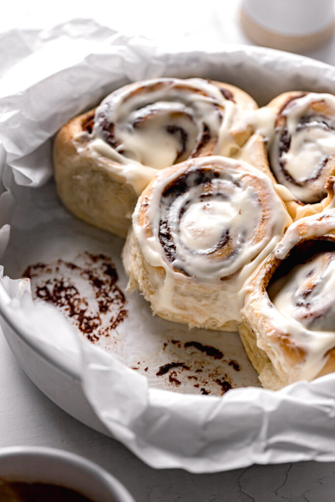 cardamom cinnamon rolls in parchment lined cake pan