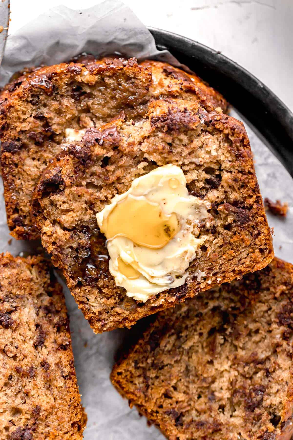 slices of honey banana bread with butter and honey on top.