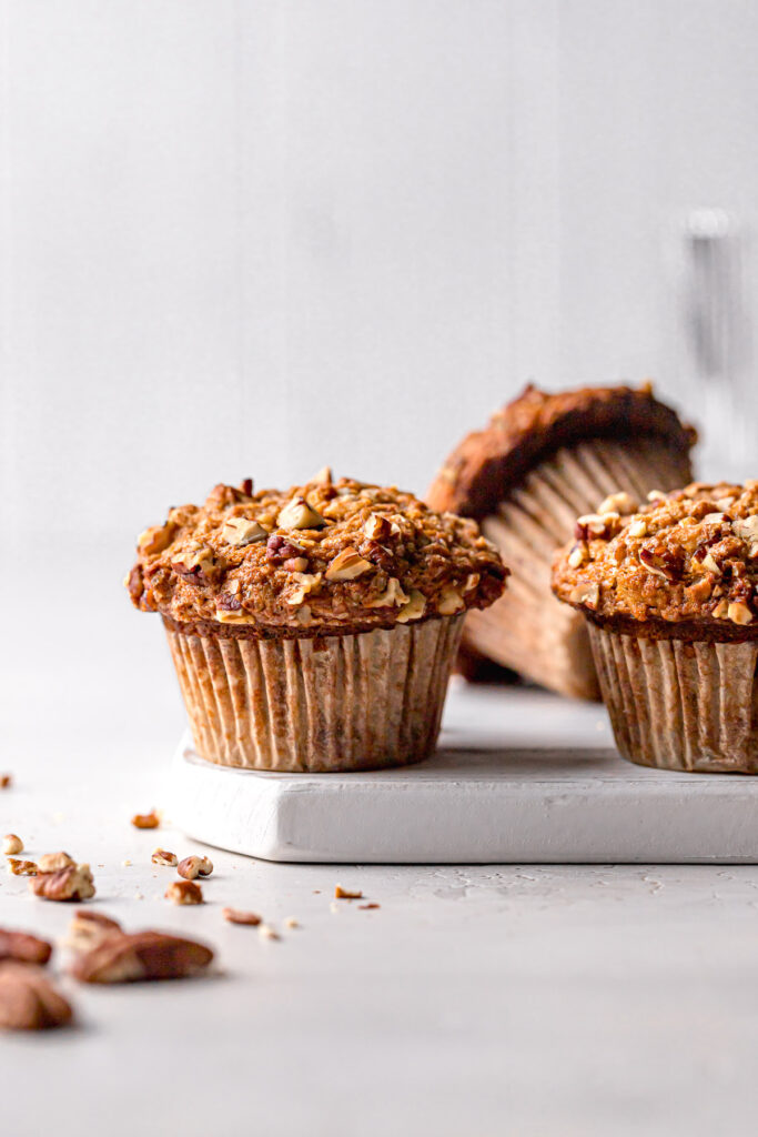 small batch banana carrot muffins on white wooden board