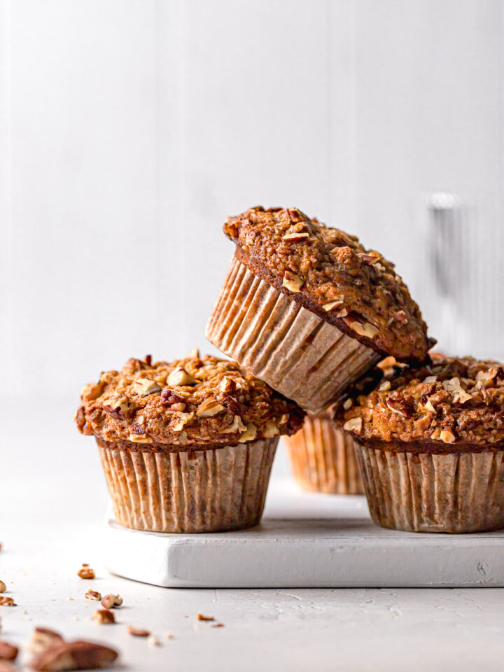 banana carrot muffins stacked on white wooden board