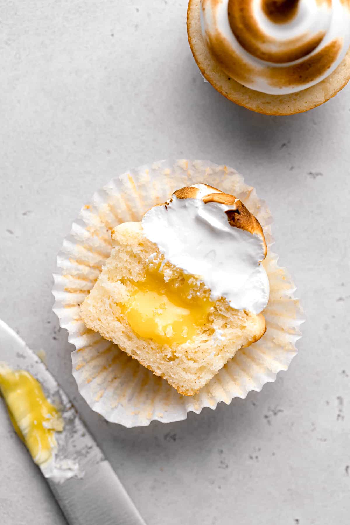 lemon meringue cupcake cut in half to show lemon curd.