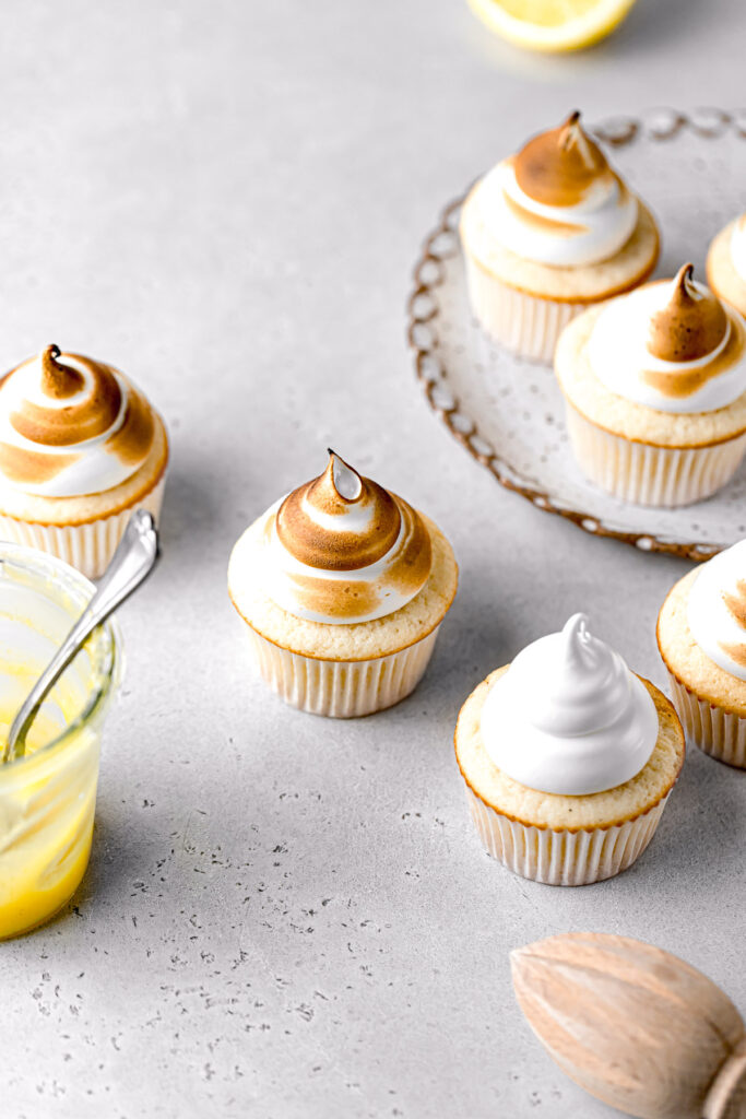 lemon meringue cupcakes on plate and surrounding it 