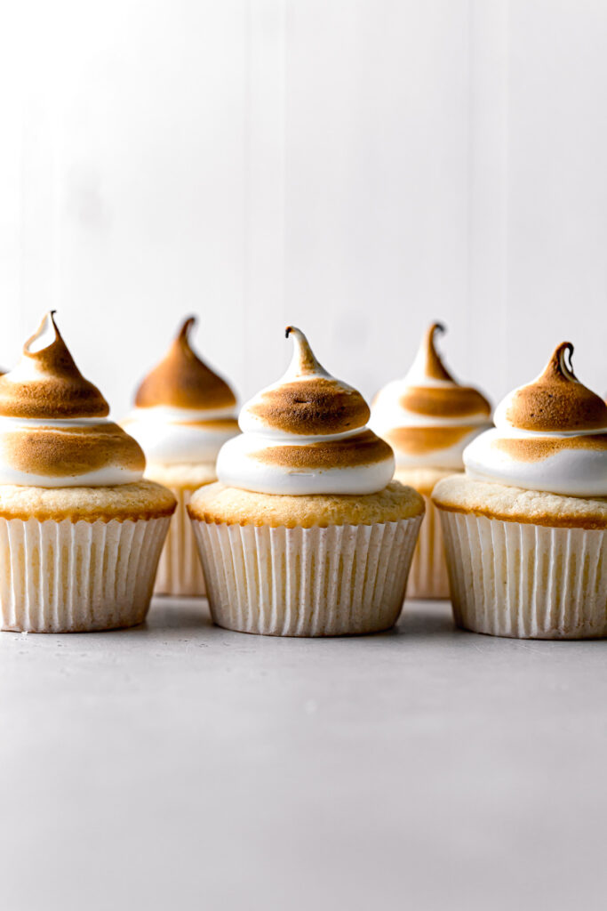 lemon cupcakes with torched meringue lined up in a row
