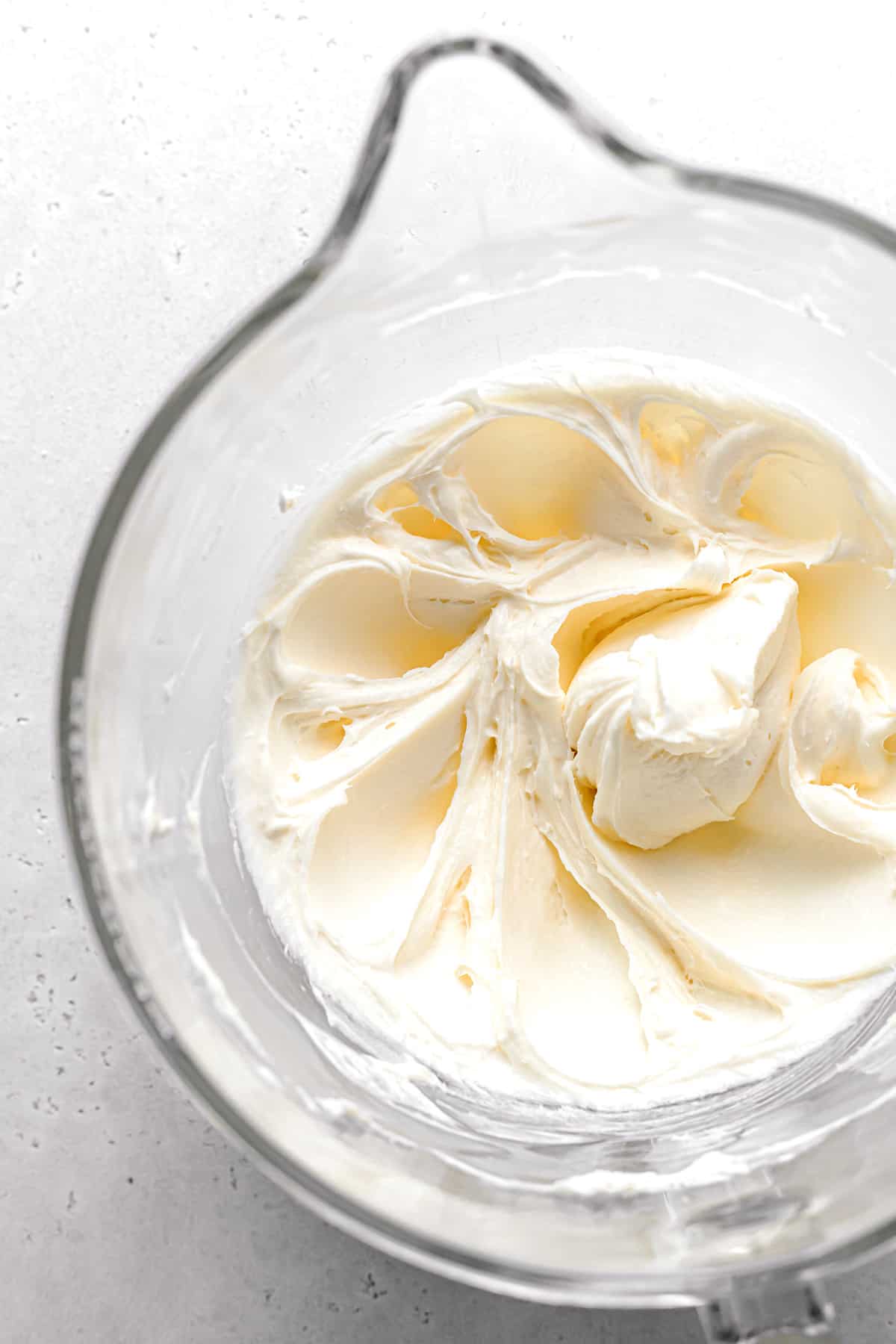 butter, cream cheese, and sugar creamed together in glass bowl.
