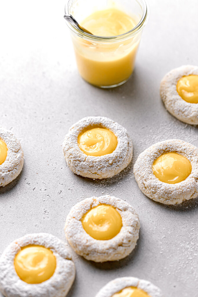 lemon curd cookies with powder sugar and a glass of tart lemon curd