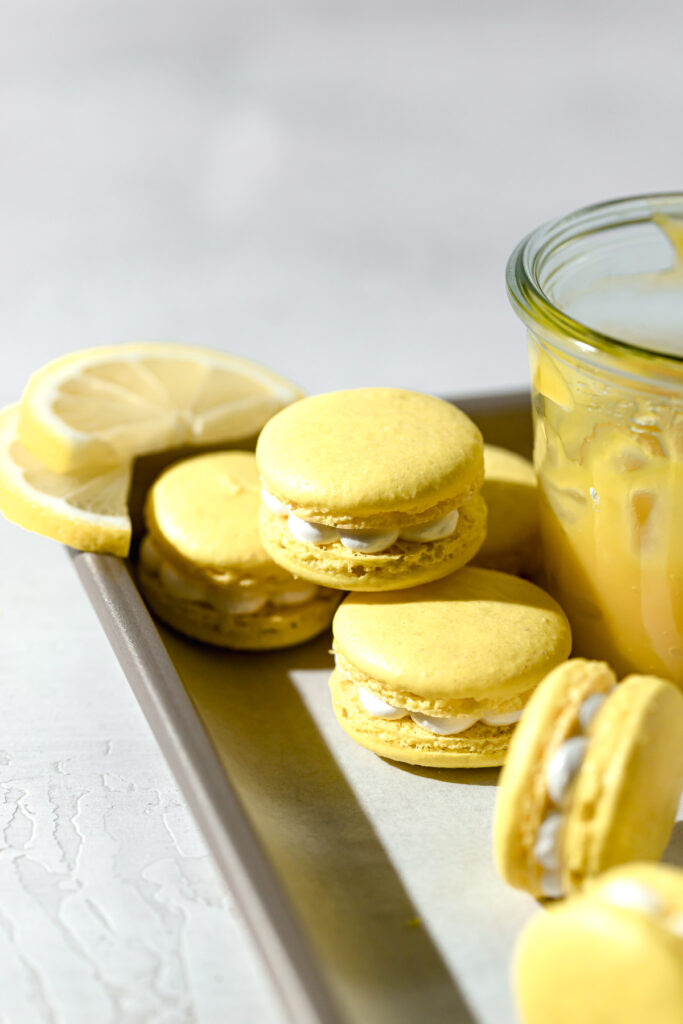 lemon curd macarons with swiss meringue on baking sheet