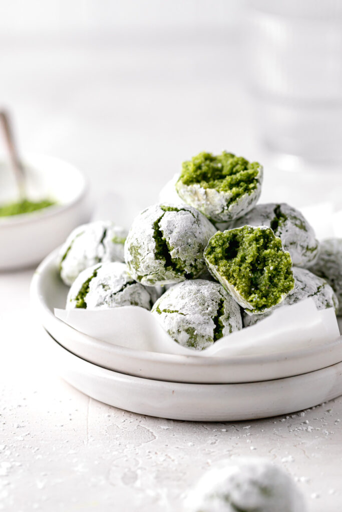 matcha amaretti cookies piled on stacked white plates