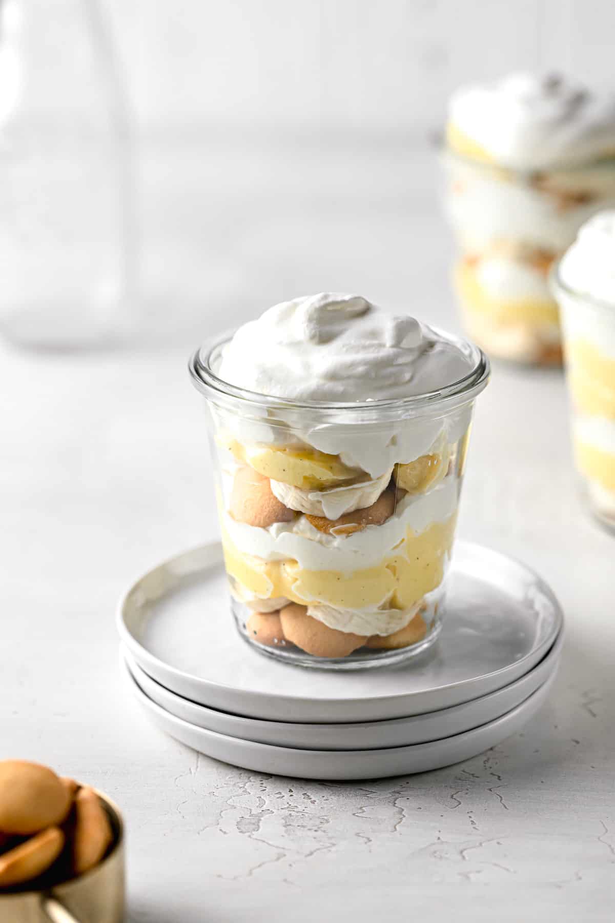 banana pudding jar on stacked plate with two jars in background.