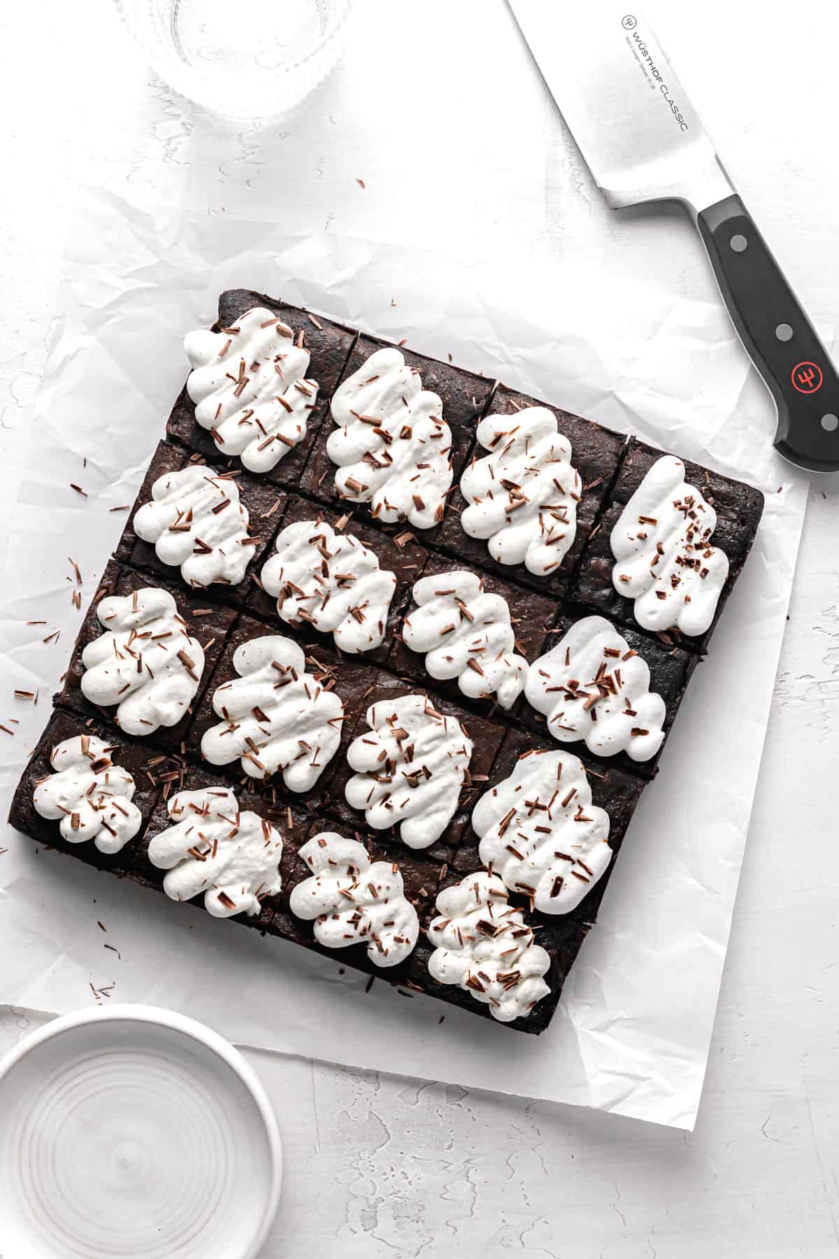 black forest brownies on parchment paper with knife.