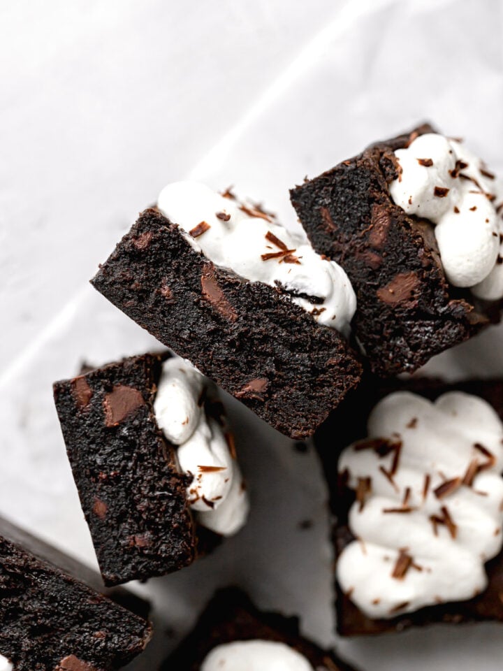 chocolate cherry brownies with whipped cream stacked on their sides