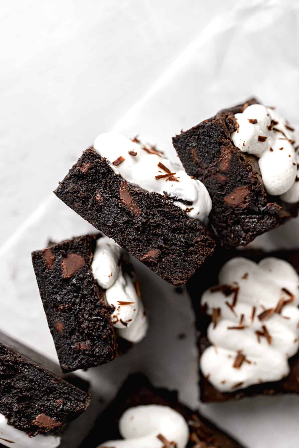 chocolate cherry brownies with whipped cream stacked on their sides