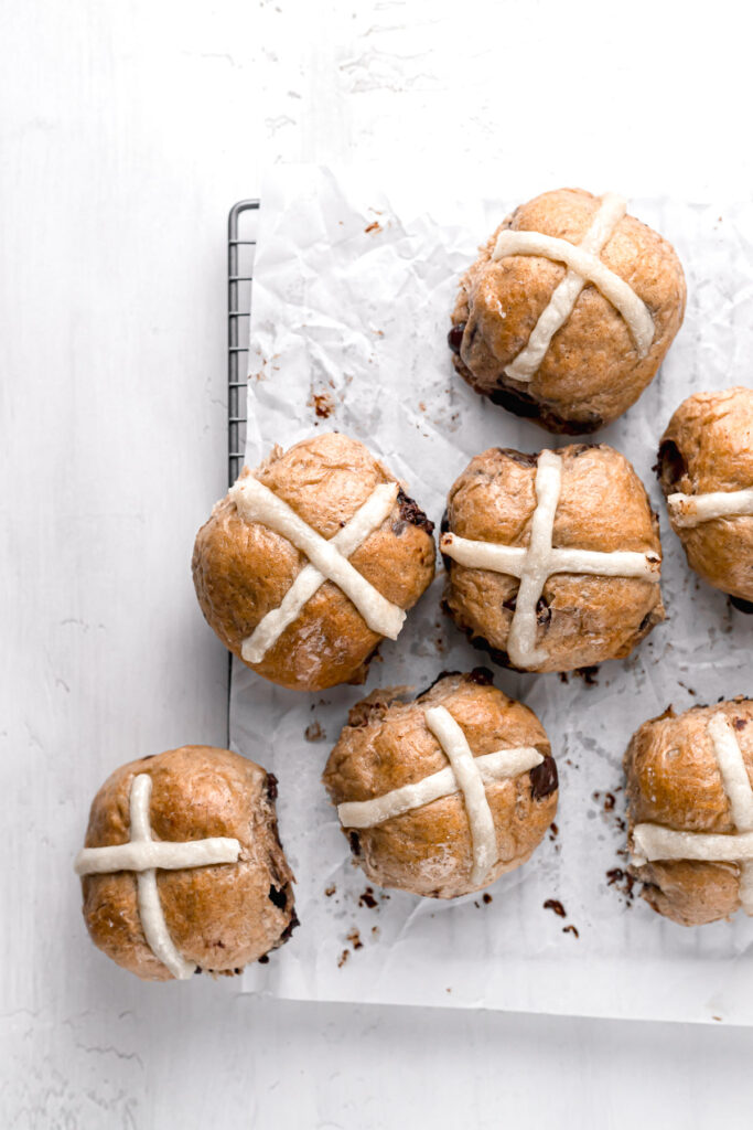 chocolate chip hot cross buns on parchment lined wire rack