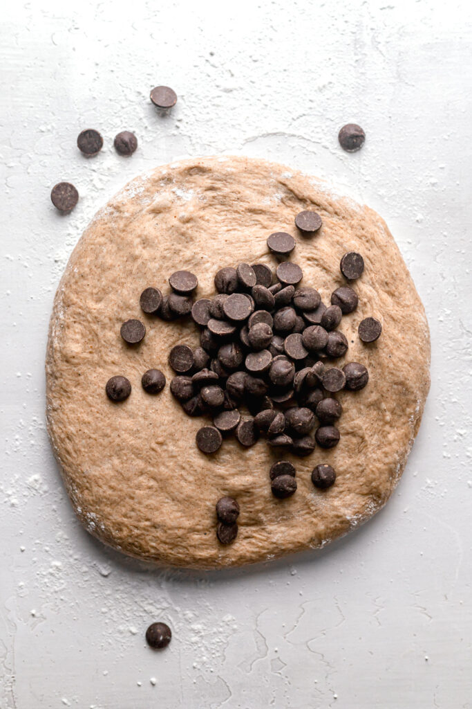 dough spread out with chocolate chips in the center