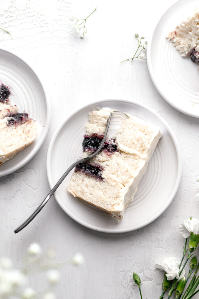 slice of lemon blueberry jam cake on white plate with fork