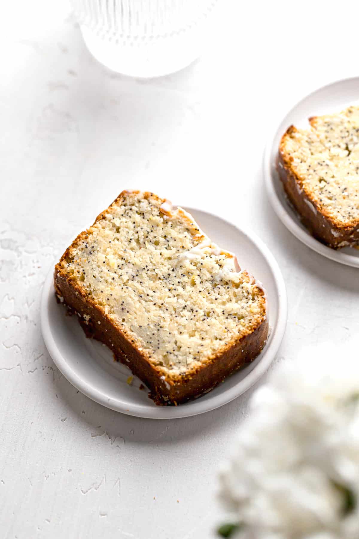 slice of lemon poppy seed loaf on small white plate.