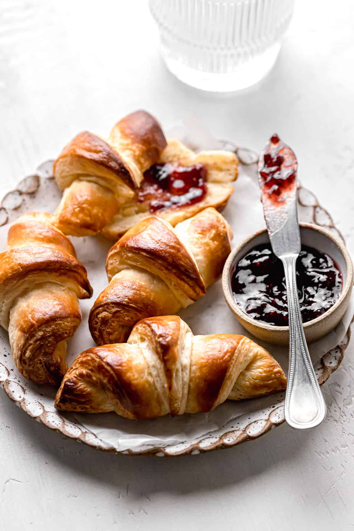 small batch mini croissants on plate with jam.
