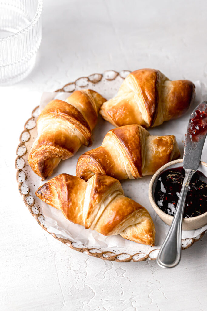 small batch mini croissants on a small plate with a bowl of jam