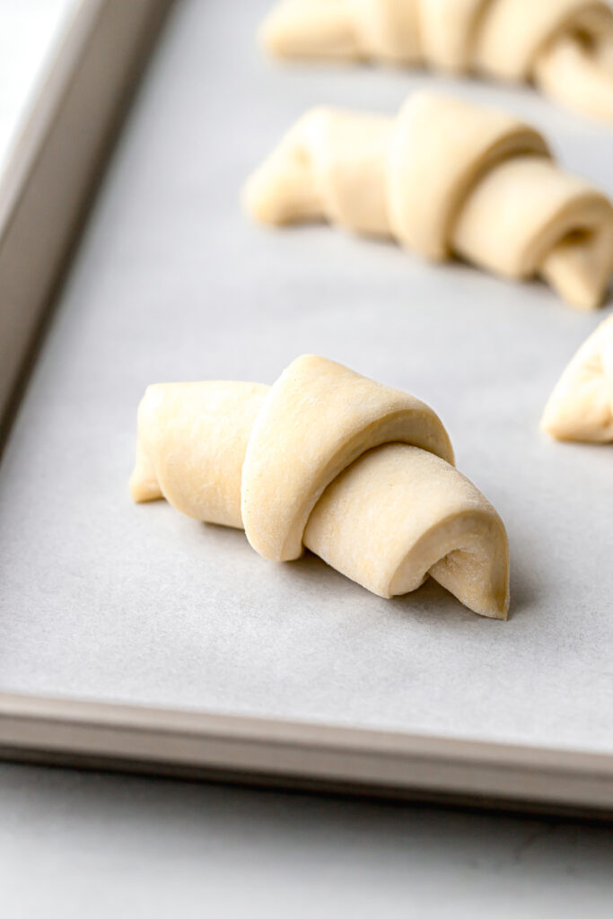 shaped croissant dough on parchment lined baking sheet